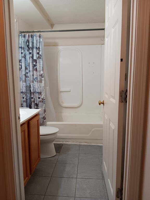 full bathroom with tile flooring, shower / tub combo with curtain, vanity, and toilet