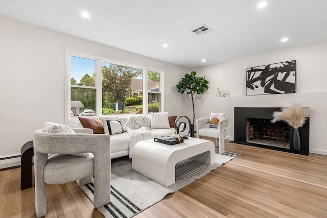 26 Parsons Dr, Swampscott, MA 01907 - living room featuring light wood-style floors, recessed lighting, a fireplace, and a baseboard radiator