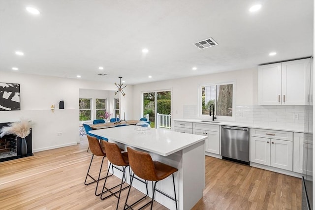 26 Parsons Dr, Swampscott, MA 01907 - kitchen with dishwasher, a sink, a center island, light wood finished floors, and a kitchen bar