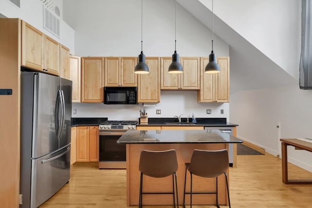 kitchen featuring a kitchen island, light brown cabinetry, and stainless steel appliances