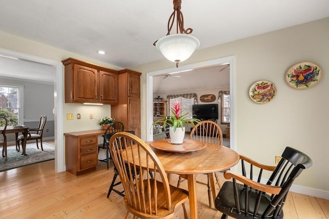 dining room with light wood finished floors, recessed lighting, built in study area, and baseboards