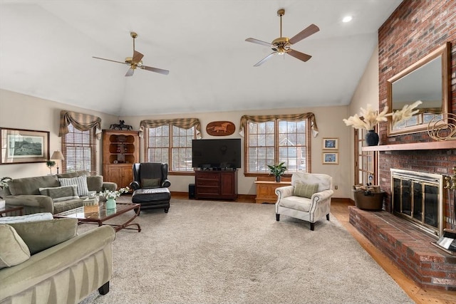 living room featuring high vaulted ceiling, a fireplace, a ceiling fan, baseboards, and carpet