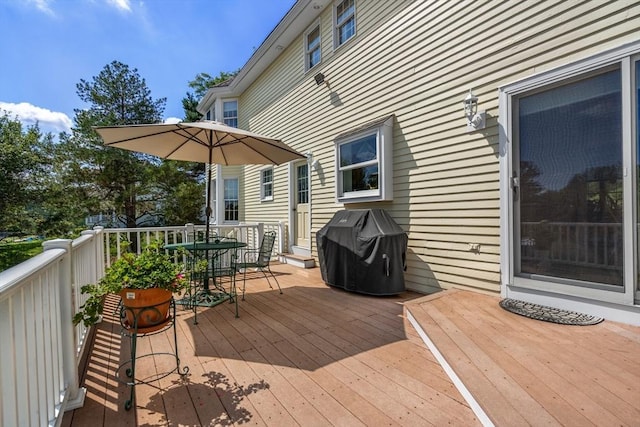 wooden terrace featuring outdoor dining area and grilling area