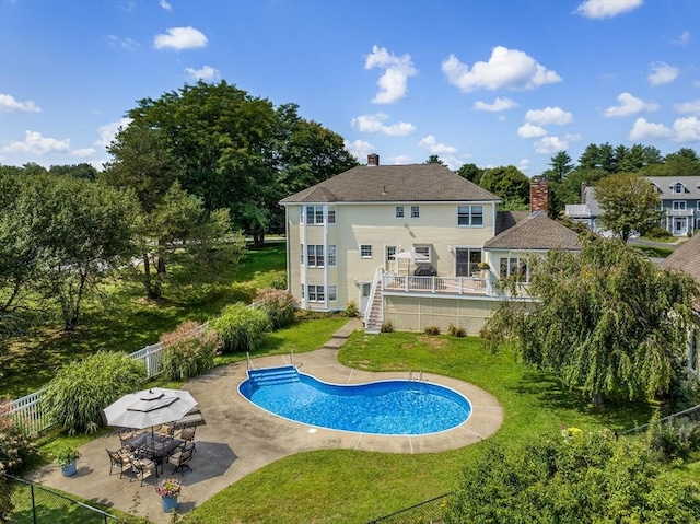 back of property featuring a fenced in pool, fence private yard, a deck, a yard, and a patio area