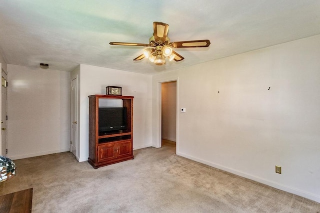 unfurnished living room with a ceiling fan, light carpet, and baseboards