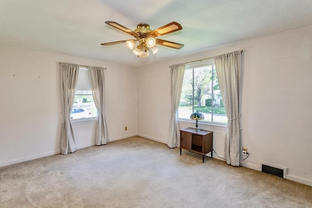 empty room featuring healthy amount of natural light, carpet floors, and ceiling fan