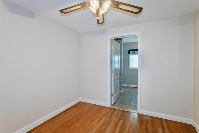 unfurnished bedroom featuring light wood-style flooring, baseboards, and ceiling fan