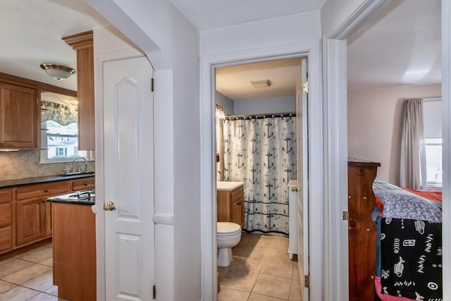 full bathroom featuring tile patterned flooring, vanity, decorative backsplash, and toilet