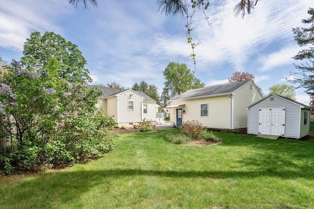 rear view of property featuring an outdoor structure, a lawn, and a shed