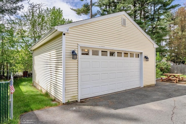 detached garage featuring fence