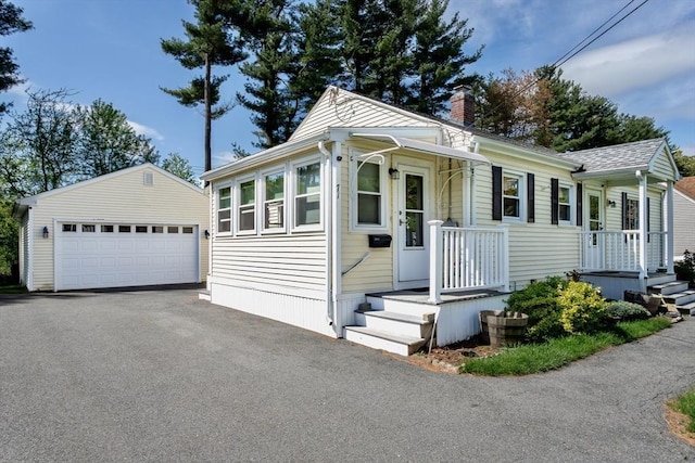 view of front of home with an outbuilding, a chimney, and a detached garage