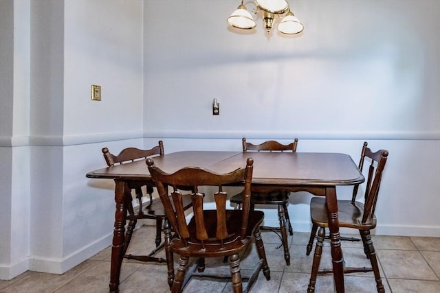 dining area with a chandelier, light tile patterned floors, and baseboards