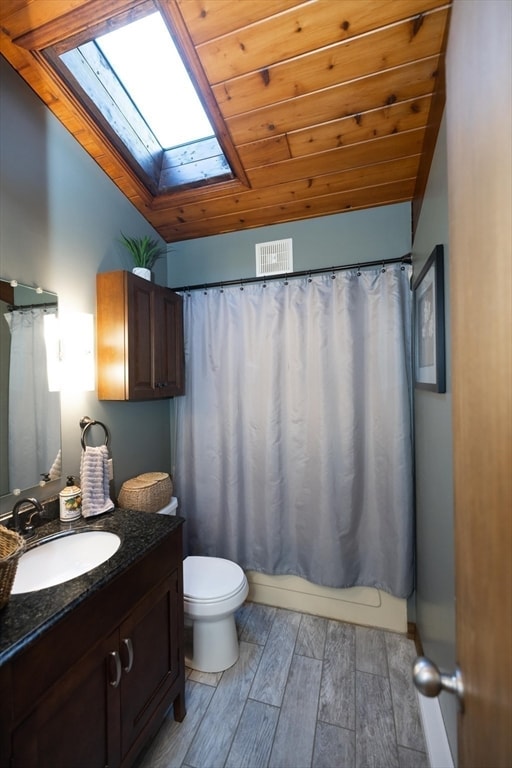 full bathroom with hardwood / wood-style floors, vanity, shower / bathtub combination with curtain, and wooden ceiling