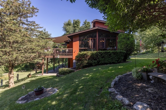 view of yard featuring a wooden deck and a sunroom