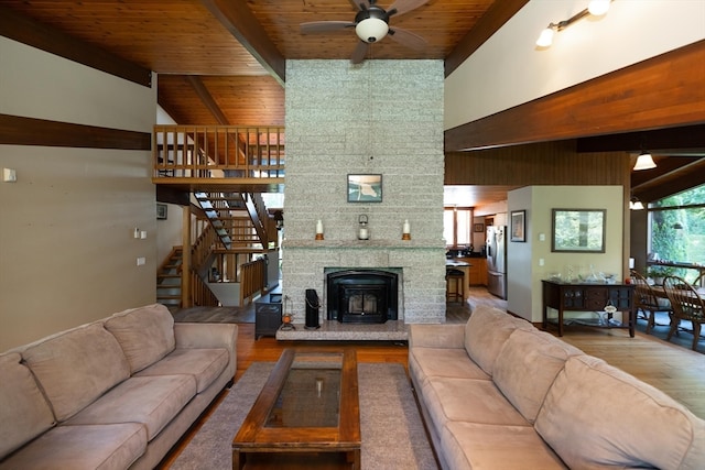 living room with hardwood / wood-style flooring, ceiling fan, vaulted ceiling with beams, and wooden ceiling