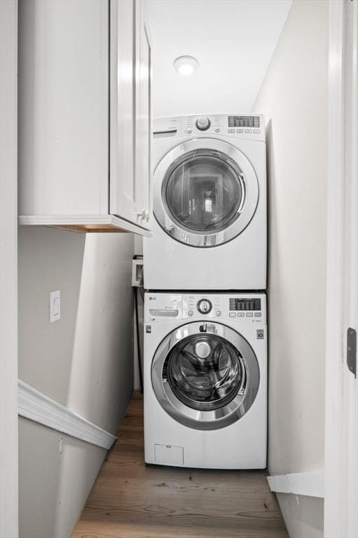 4 Rowley Rd, Topsfield, MA 01983 - laundry room with stacked washing machine and dryer, cabinet space, and wood finished floors