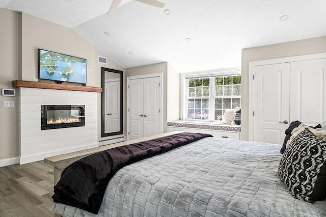 4 Rowley Rd, Topsfield, MA 01983 - bedroom featuring multiple closets, wood finished floors, baseboards, a glass covered fireplace, and vaulted ceiling