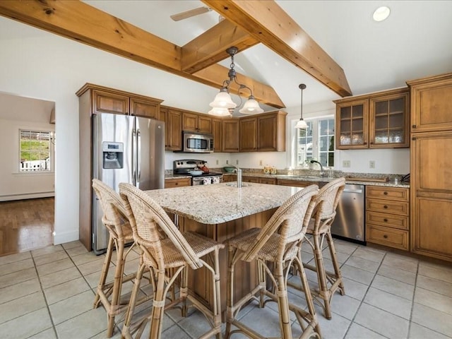 kitchen featuring light stone countertops, brown cabinets, beam ceiling, light tile patterned floors, and appliances with stainless steel finishes