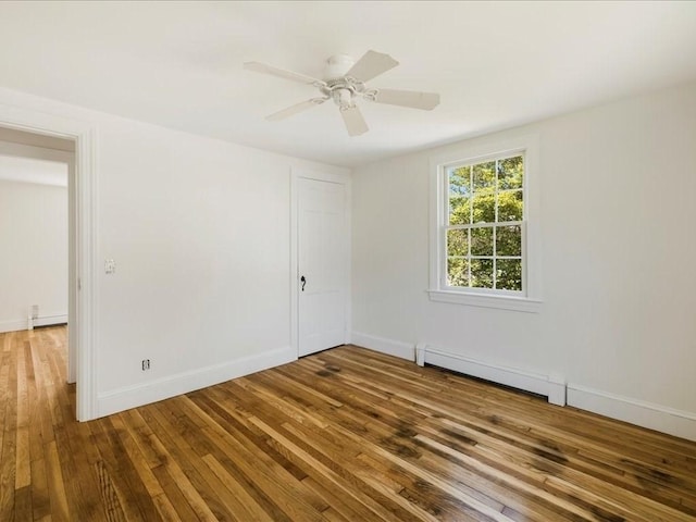 unfurnished room featuring hardwood / wood-style floors, baseboards, a ceiling fan, and a baseboard radiator