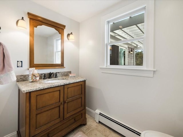 bathroom with a healthy amount of sunlight, baseboards, a baseboard heating unit, and vanity