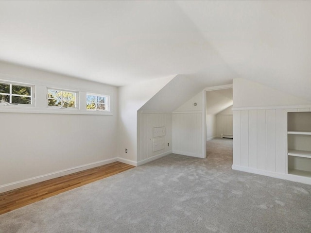 additional living space featuring lofted ceiling, baseboards, baseboard heating, and carpet floors