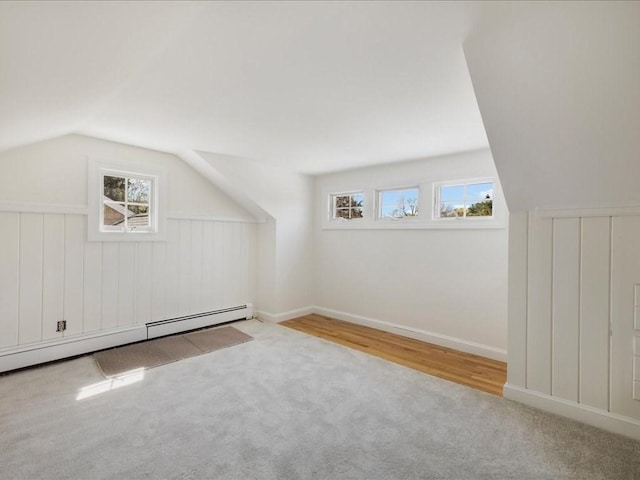 bonus room featuring a baseboard heating unit, carpet flooring, and vaulted ceiling