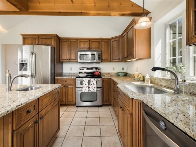 kitchen with lofted ceiling with beams, appliances with stainless steel finishes, and a sink