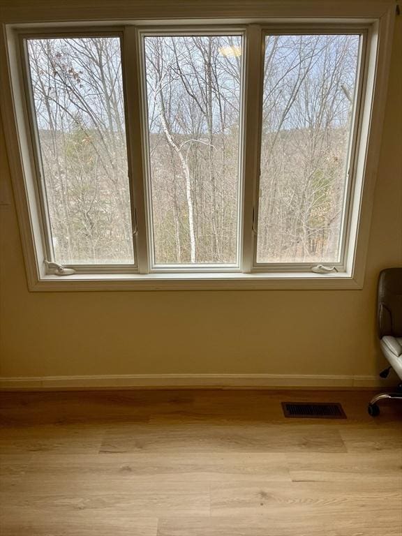 room details featuring baseboards, visible vents, and wood finished floors