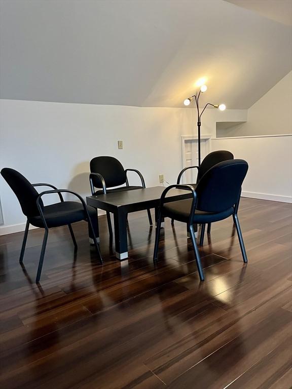 sitting room featuring lofted ceiling, baseboards, and dark wood finished floors