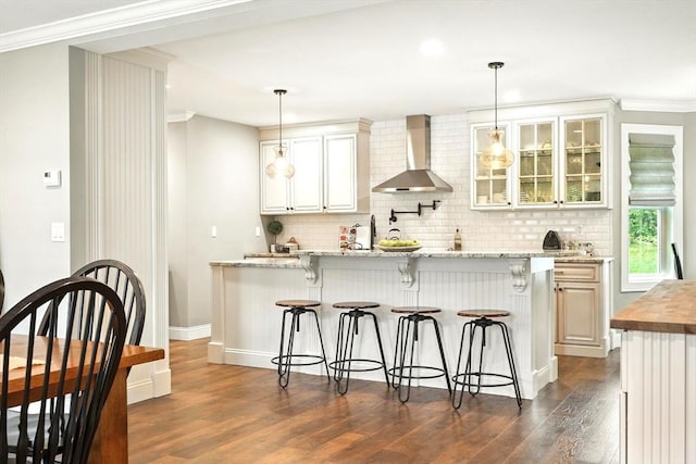 21 Carla Ln, Wilbraham, MA 01095 - kitchen with wall chimney exhaust hood, dark wood-style floors, a breakfast bar area, crown molding, and backsplash