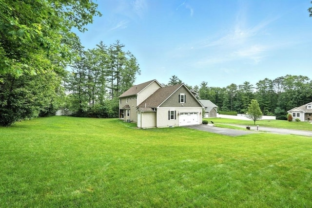 21 Carla Ln, Wilbraham, MA 01095 - view of side of home with asphalt driveway, a yard, an attached garage, and view of wooded area
