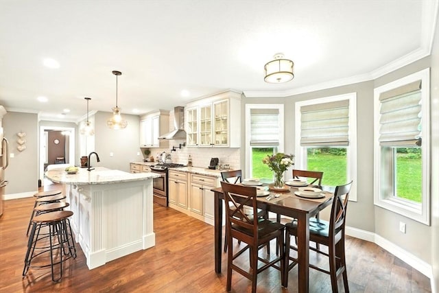 21 Carla Ln, Wilbraham, MA 01095 - kitchen featuring stainless steel appliances, wall chimney range hood, healthy amount of natural light, a kitchen island with sink, and crown molding