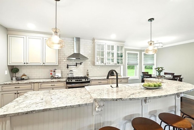 21 Carla Ln, Wilbraham, MA 01095 - kitchen with wall chimney range hood, gas stove, a kitchen breakfast bar, tasteful backsplash, and ornamental molding