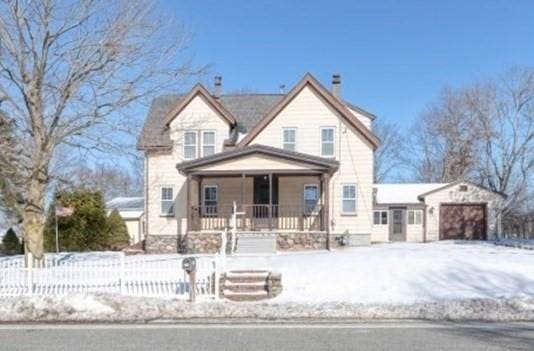 view of front of property with an attached garage, covered porch, and a fenced front yard