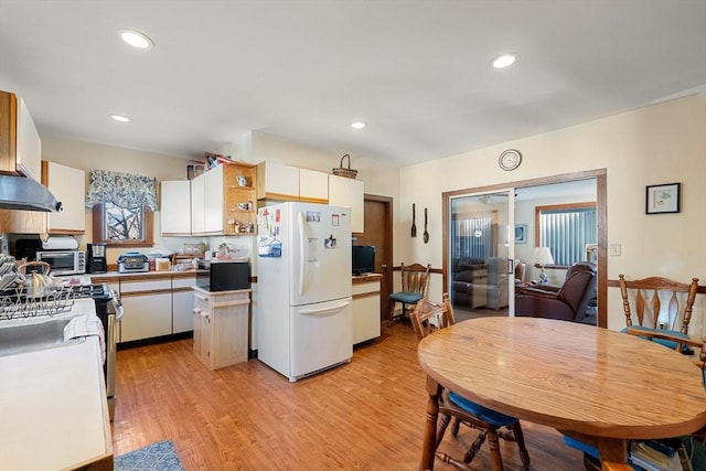 kitchen with recessed lighting, under cabinet range hood, appliances with stainless steel finishes, white cabinetry, and light wood-type flooring