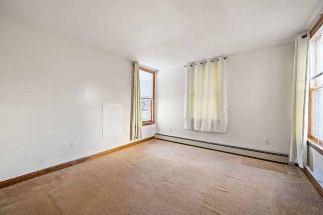 empty room featuring baseboards, a baseboard heating unit, carpet floors, and a healthy amount of sunlight