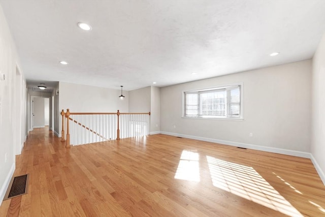 spare room with light wood-style flooring, recessed lighting, visible vents, and baseboards