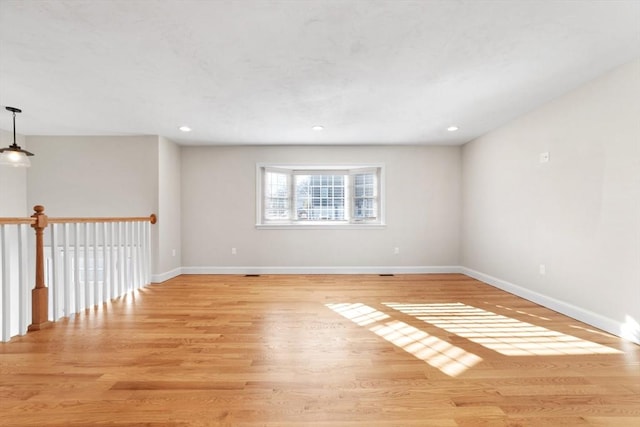 empty room featuring recessed lighting, wood finished floors, and baseboards