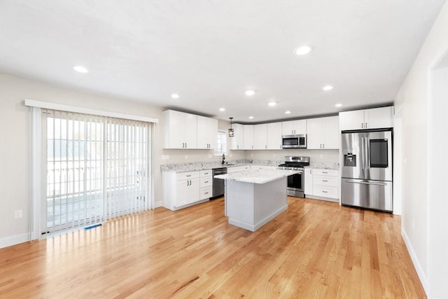 kitchen featuring a healthy amount of sunlight, light wood-style floors, appliances with stainless steel finishes, and white cabinets