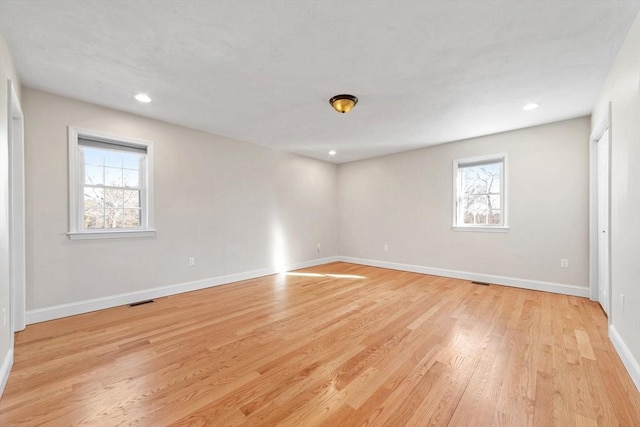 spare room featuring light wood-style flooring, visible vents, baseboards, and recessed lighting