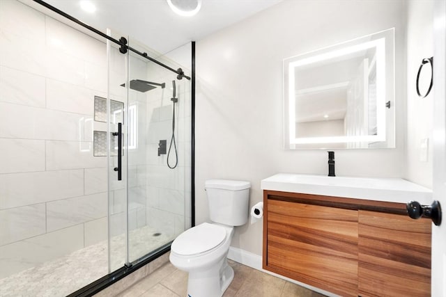 bathroom with toilet, a shower stall, vanity, tile patterned flooring, and baseboards