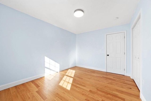 empty room featuring light wood finished floors and baseboards