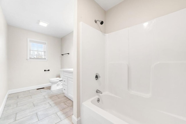 bathroom with baseboards, visible vents, toilet, vanity, and shower / bathing tub combination