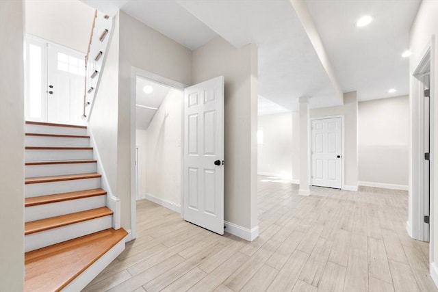 staircase with baseboards, wood finished floors, and recessed lighting