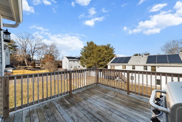 wooden terrace featuring a residential view and a lawn