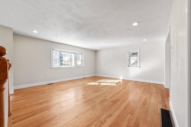 interior space with light wood finished floors, baseboards, visible vents, and recessed lighting