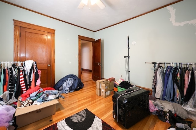 bedroom with wood-type flooring, ornamental molding, and ceiling fan