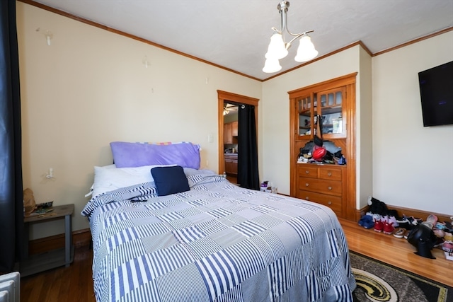 bedroom featuring ornamental molding, dark wood-type flooring, and a chandelier