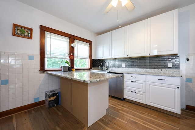 kitchen with dishwasher, light stone counters, light wood-type flooring, and white cabinetry