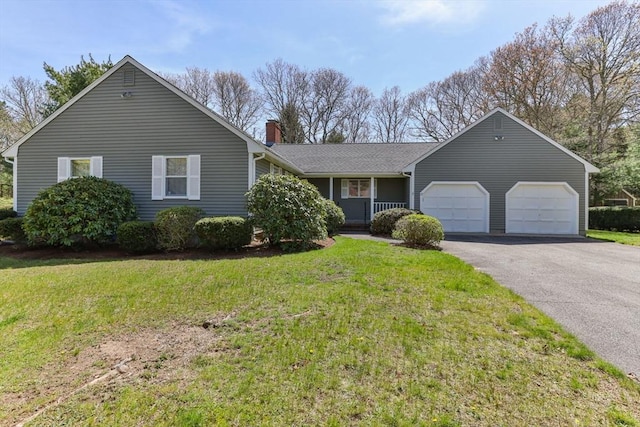 ranch-style house featuring an attached garage, a chimney, a front yard, and aphalt driveway